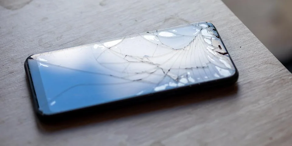 Smartphone with broken touchscreen screen on table desktop Stock Photos