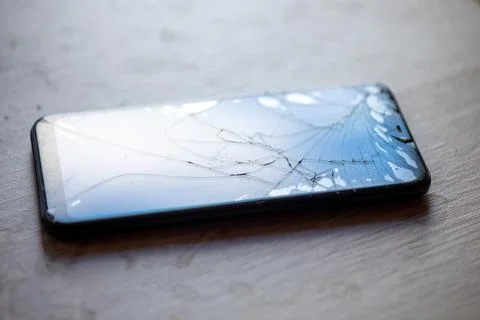 Smartphone with broken touchscreen screen on table desktop Stock Photos