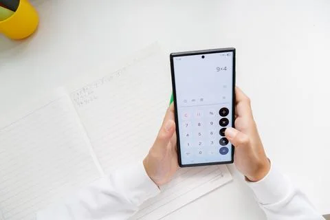 Smartphone calculator for math homework and everyday calculations. Using a mo Stock Photos