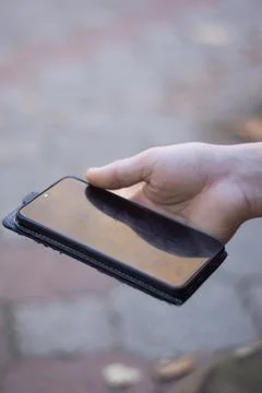 Smartphone in a case in a man's hands Stock Photos