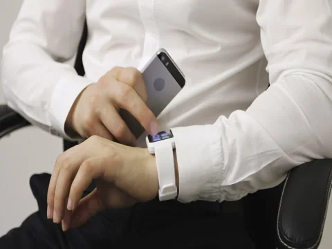 Smartphone cell and a smartwatch being connected together and used. Stock Footage 73875741