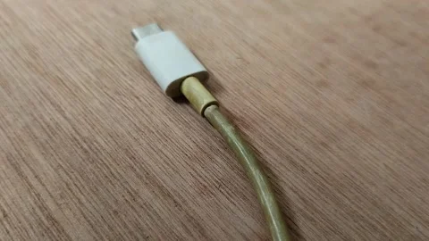 Smartphone charging cable turns yellow on wood texture background 動画素材 296865577