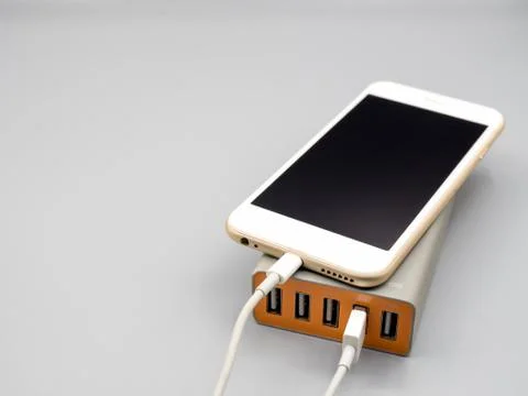 Smartphone charging with multiport USB power adaptor Foto stock