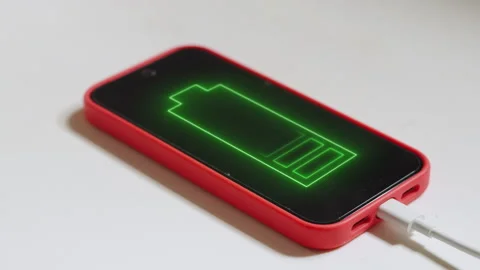 Smartphone Charging on Table with Animated Green Battery Icon on Screen Stock Footage 337520858