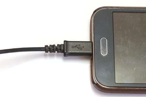Smartphone charging on white Stock Photos