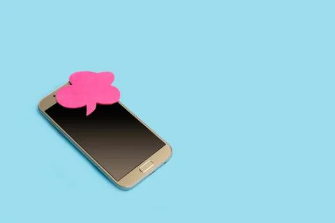 A smartphone with a chat bubble on a light blue background Stock Photos