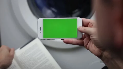 Smartphone with chroma green screen. Running washing machine in the background. Video stock 165662855
