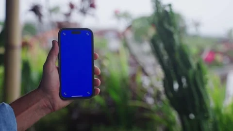 Smartphone with chroma key close-up. Holding mobile phone with blue screen on Video stock 268449003