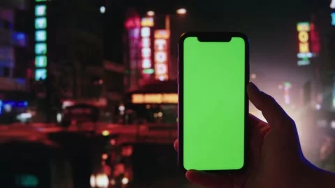 Smartphone with chroma key close-up. Mobile phone with green screen on big city 動画素材 200489264