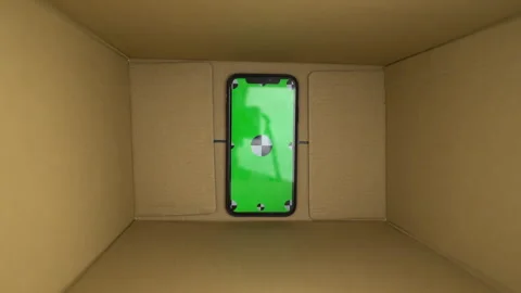 Smartphone with chromakey green screen inside box zoom out. delivery package Stock Footage 246629960