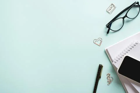 Smartphone, clean blank notepad, glasses, pen, paper clips, pencil on a light Stock Photos