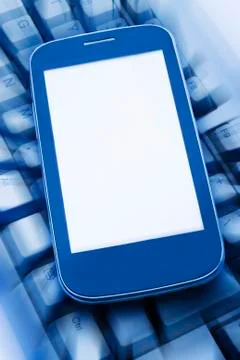 Smartphone on the computer keyboard Stock Photos