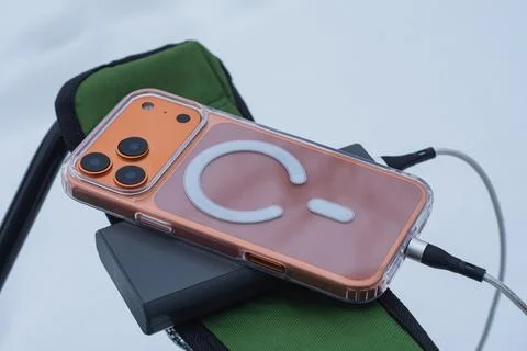 Smartphone connected to an external battery pack on a folding tourist chair o Foto stock