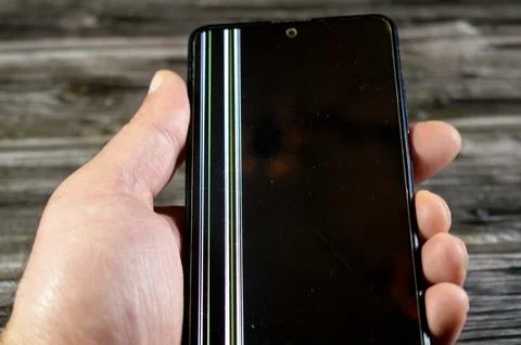 A smartphone with a damaged display, with a vertical lines on the screen, t.. Stock Photos