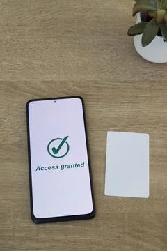 Smartphone Displaying Access Granted Message with Plant and Digital Card Stock Photos
