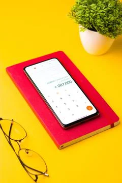 Smartphone displaying the calculator app with notes on a table Stock Photos