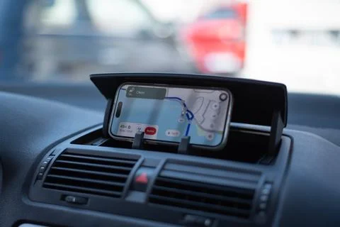 Smartphone displaying a GPS navigation map is mounted on a car dashboard 库存照片