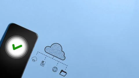 Smartphone displaying a green checkmark next to a cloud storage diagram, sy.. Foto stock