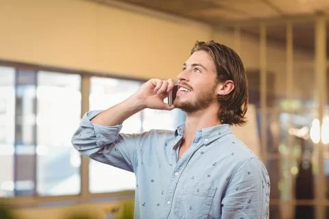 Smartphone displaying ongoing call and glowing screen inside modern office with Stock Photos