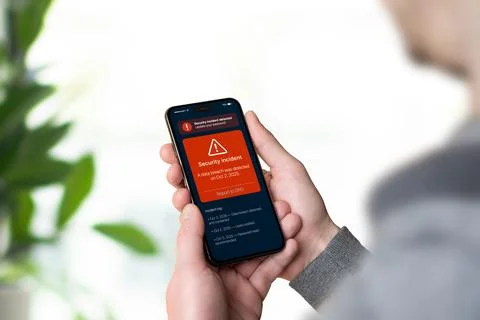 Smartphone displaying red GDPR security alert about data breach with report.. Stock Photos