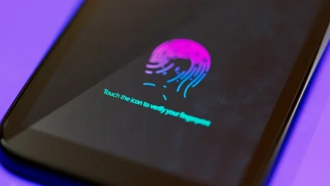 A smartphone displaying on the screen an icon to verify a fingerprint. Security. Stock Footage 145764065