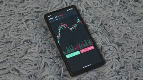 Smartphone displaying stock market trading application with financial Stock Footage 341569341