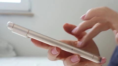Smartphone in female hands on a light background. Stock Footage 277264846