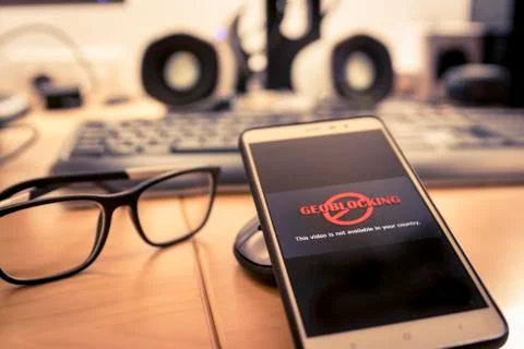 Smartphone with Geo-blocking on screen. Stock Photos