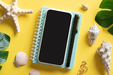 A smartphone, glasses, a blank notebook and Monstera Deliciosa leaves and she Stock Photos