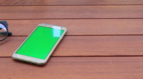Smartphone with glasses on table Stock Footage 64620859