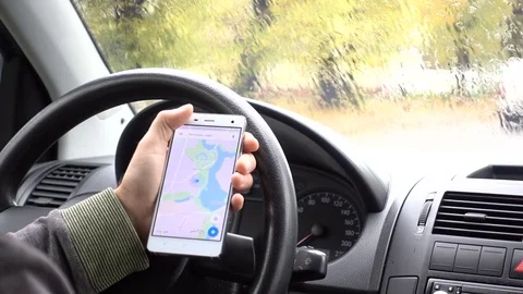 Smartphone with Google maps gps navigation for direction, location. Man drive Stock Footage 81660657