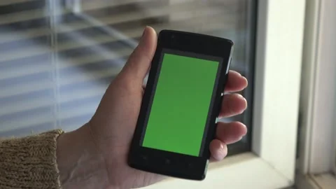 Smartphone with a green background on the screen. Stock Footage 154866599