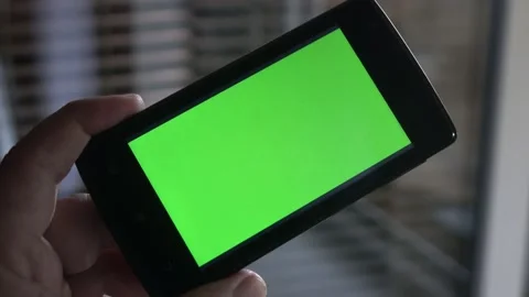 Smartphone with a green background on the screen. Stock Footage 154867233