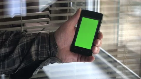 Smartphone with a green background on the screen. Stock Footage 154867640