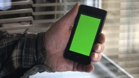 Smartphone with a green background on the screen. Stock Footage 154867665