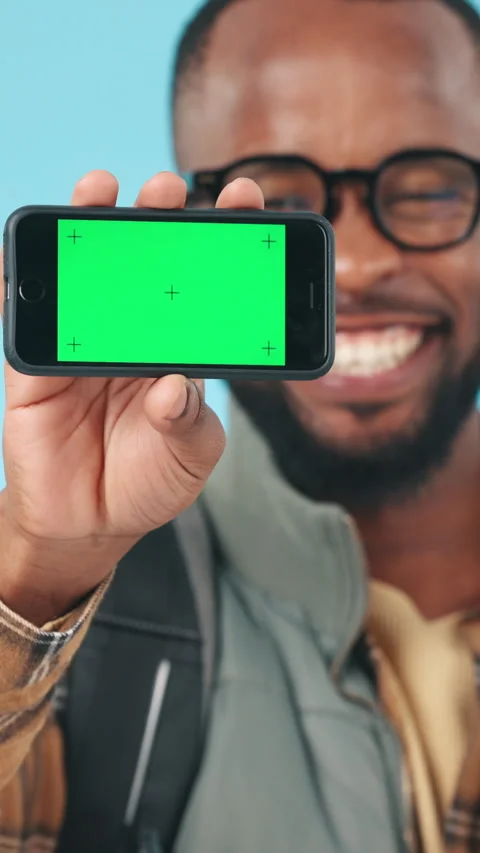 Smartphone, green screen and black man with face, hand and communication on blue Stock Footage 331839596