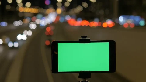 A smartphone with a green screen is fixed over the road. Against the background Video stock 93120415
