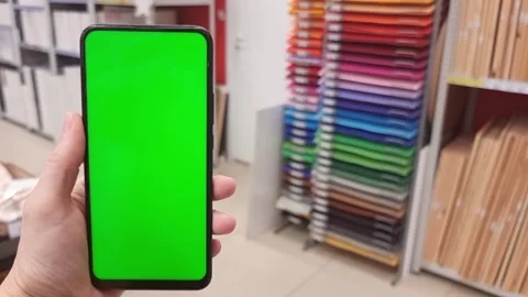 Smartphone with green screen in hand on the background of creative goods Stock Footage 282395487