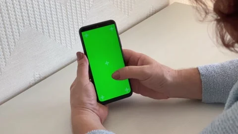 Smartphone green screen. hands of an elderly woman using a chromakey smartphone Stock Footage 221178644