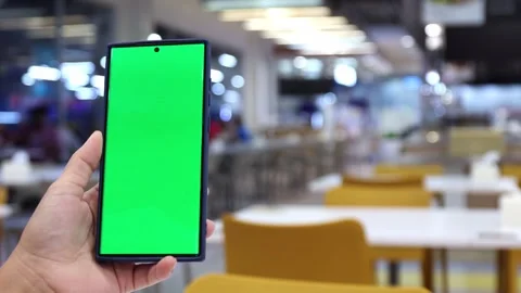 Smartphone with green screen held in hand at food court Stock Footage 328214915