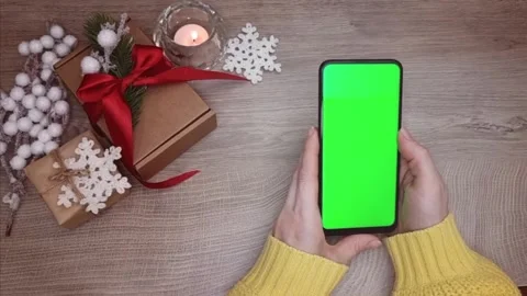 A smartphone with a green screen in his hands, top view, against the background Stock Footage 314788549