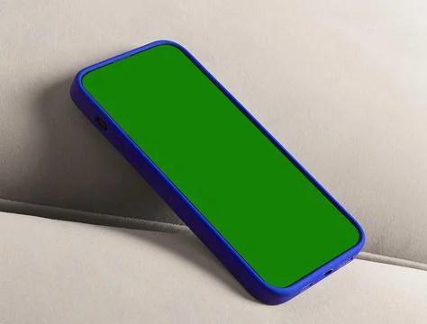 Smartphone with green screen on a sofa. Blue protective case and blank disp.. Stock Photos