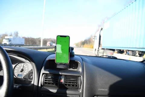 Smartphone with green screen in windshield holder in the car for navigation Stock Photos