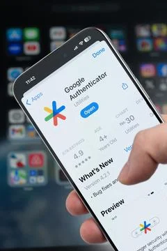 Smartphone in hand with Google authenticator app on screen Stock Photos