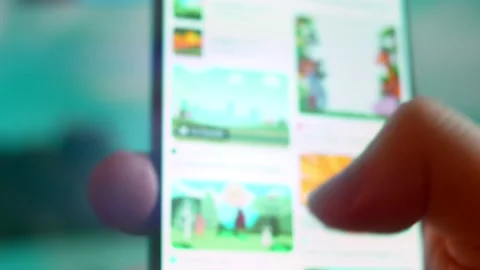 Smartphone in hand, I'm looking for information on the internet about cartoon Video stock 230948345