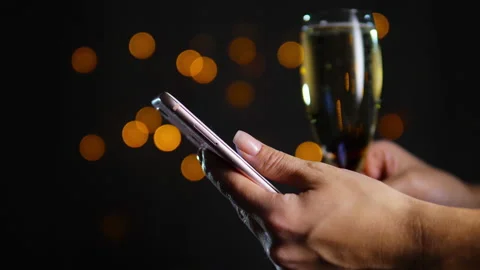 Smartphone in hands on blurred gold background Stock Footage 143331764