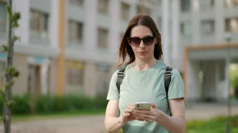 The smartphone has become an integral part of urban life for a beautiful middle Vídeos de archivo 274875789