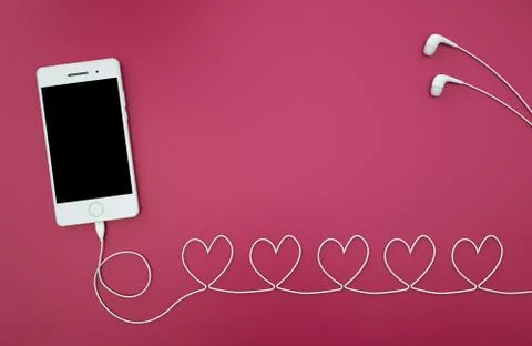 Smartphone with headset hearts shape on red background. Stock Photos