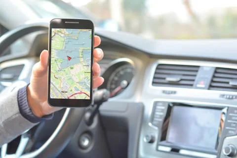 Smartphone held by man with navigation map inside a car Stock Photos