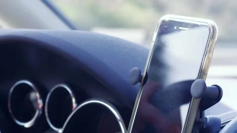 Smartphone in holder attached to car dashboard in moving automobile Stock Footage 132348627